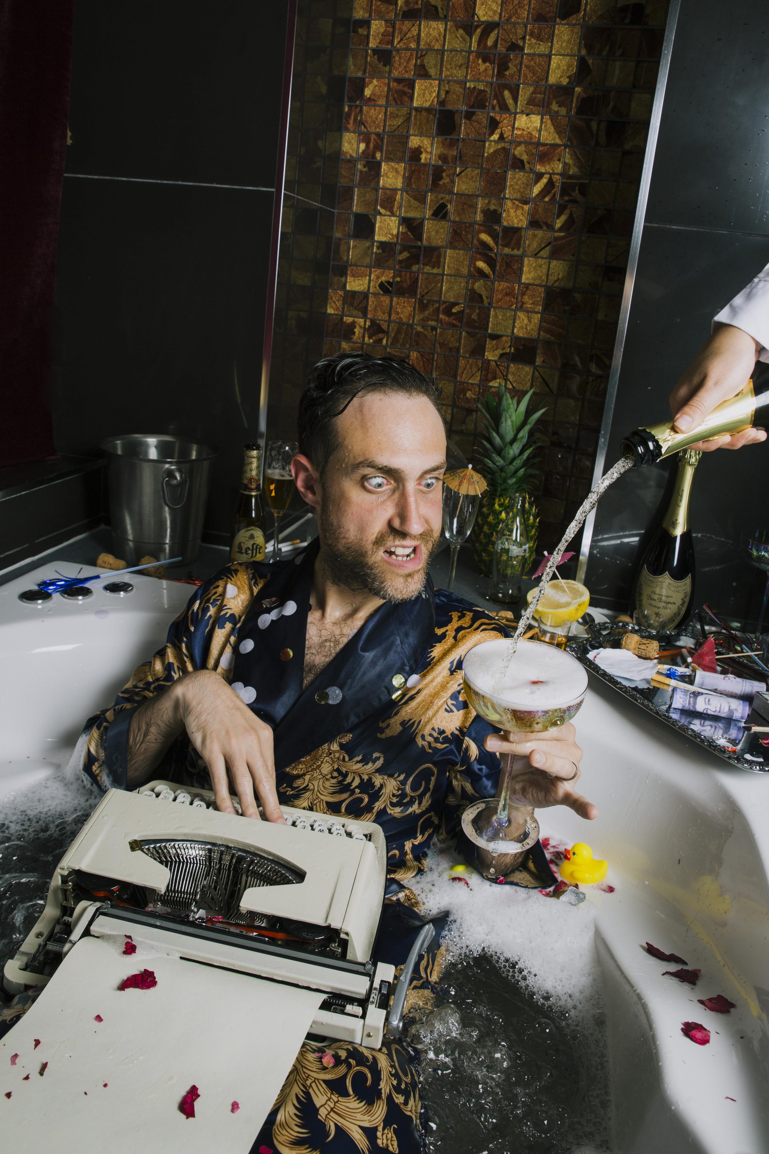 Bearyman sitting in a hot tub with champagne