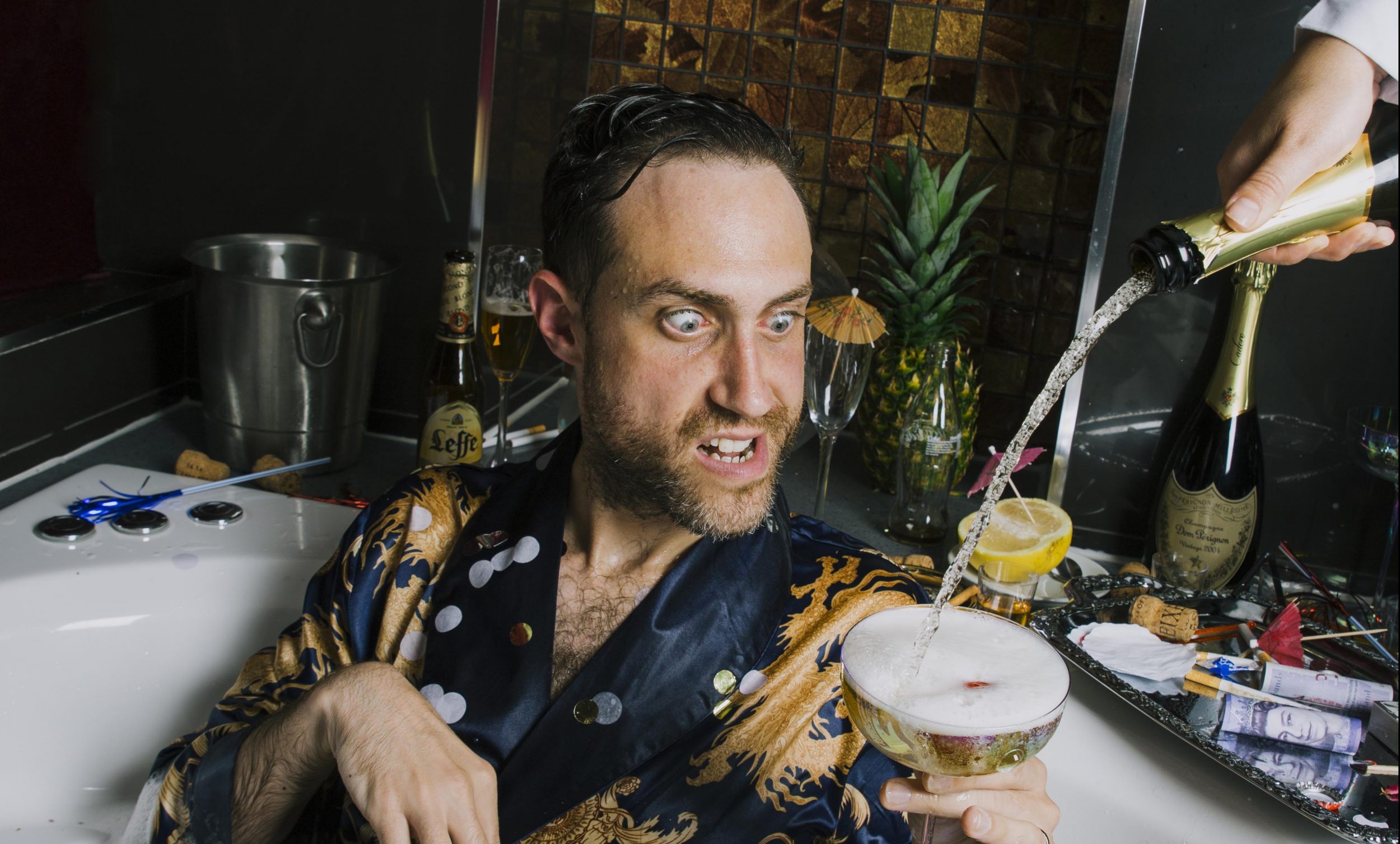 Bearyman sitting in a hot tub with champagne